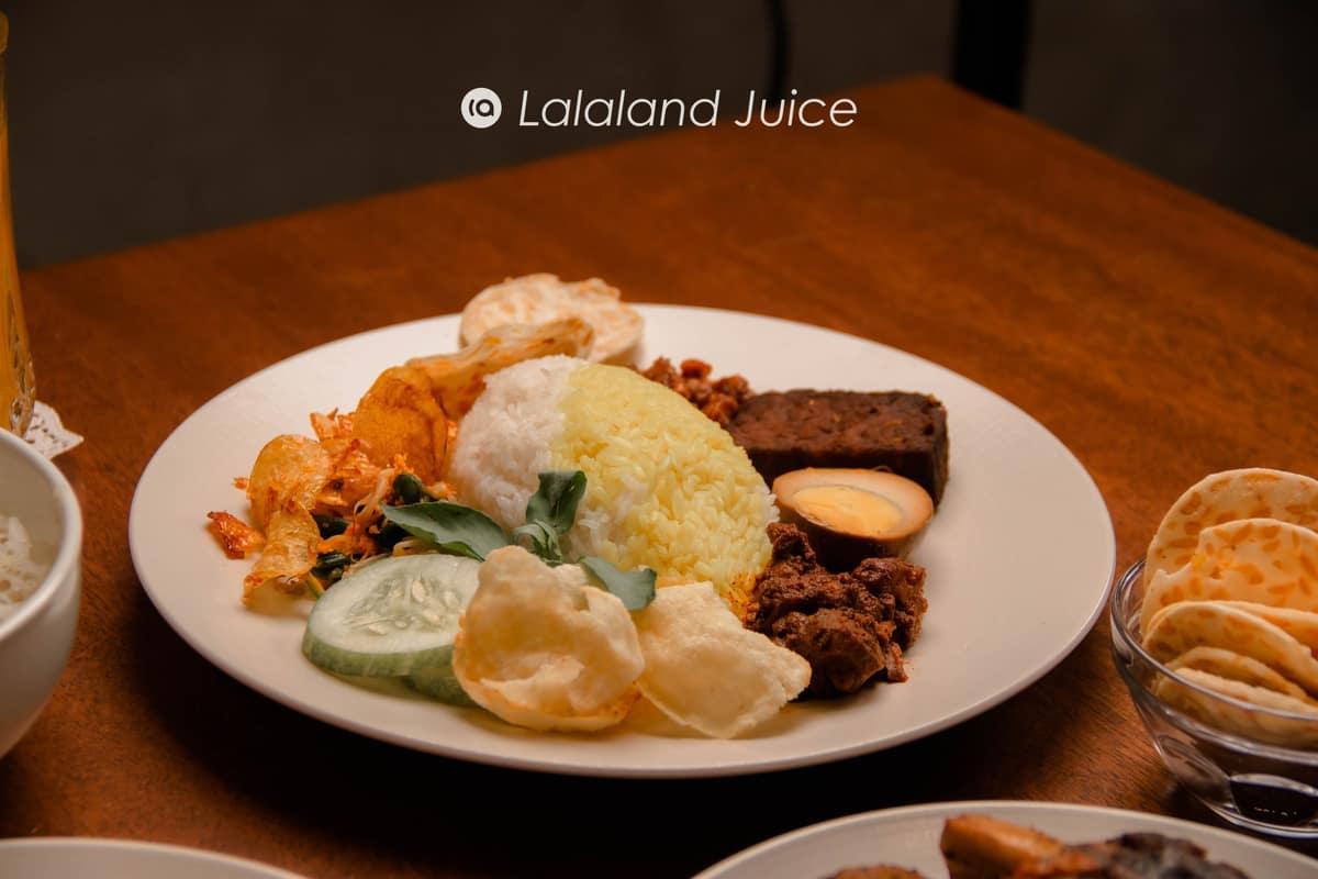 A plate of nasi padang — rice with rendang, egg, tempeh, cucumber and keropok — the economy-rice spread.