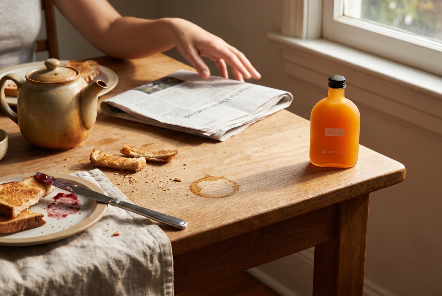 An unhurried breakfast table hours after the meal, a Lalaland bottle at the corner